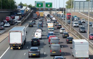 a busy highway with a green sign that says ' paddington junction ' on it