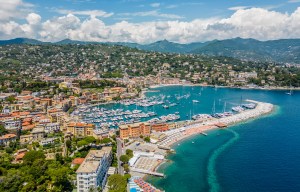 an aerial view of a harbor with boats and mountains in the background