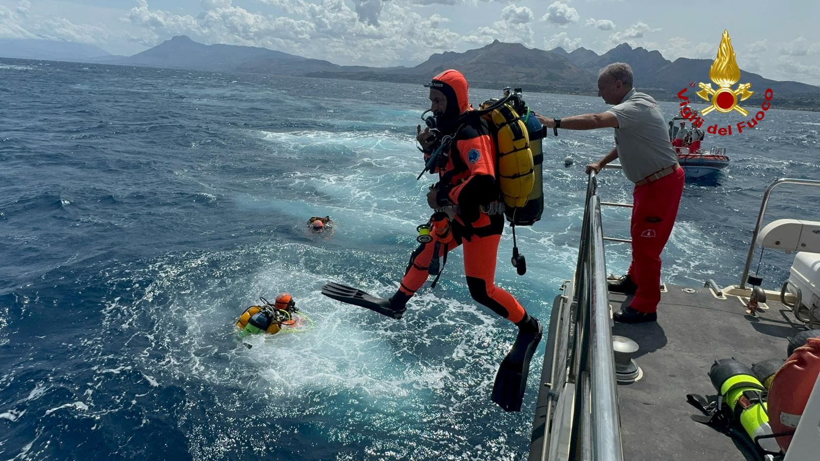 Divers plunge into the waters near the site of the wreck last week